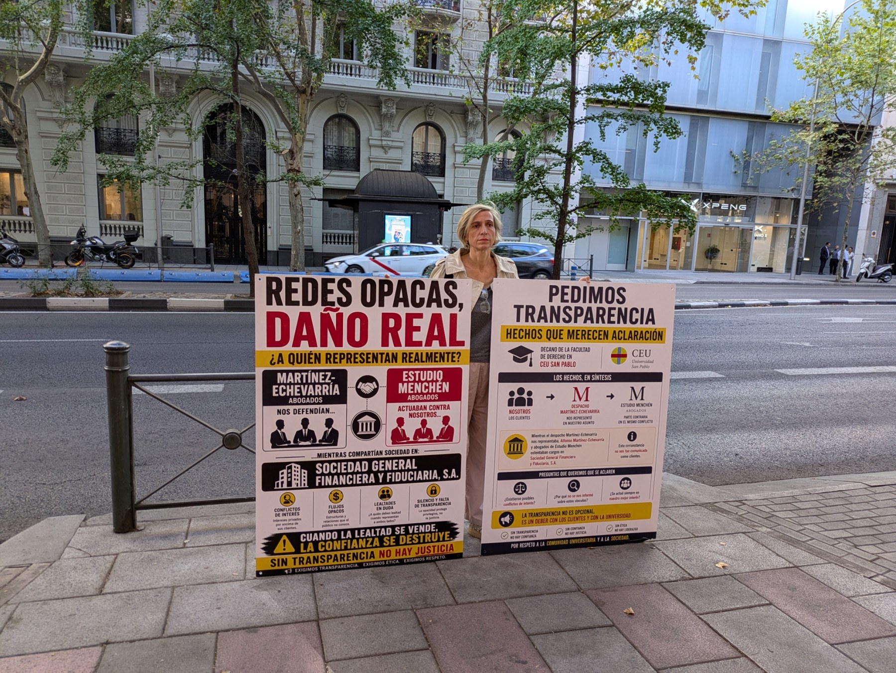 Manifestante de la campaña con dos pancartas que reclaman transparencia